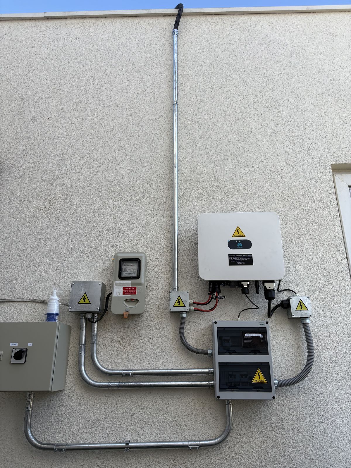 Inversor Huawei y medidor instalados en muro exterior